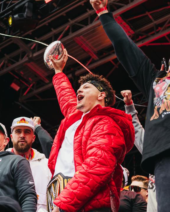 Patrick Mahomes holding up a trophy at the Superbowl parade in 2024.
