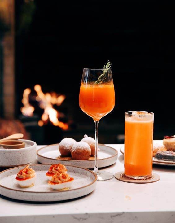 An orange-themed dinner spread, with deviled eggs and cocktails.