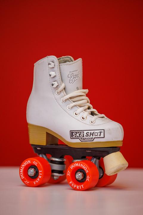 White roller skate on display with the Sk8 SHOT logo imprinted on it