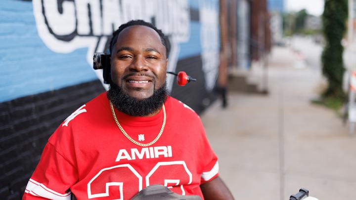 Will Smith smiling in front of the Royals World Series mural in downtown Kansas City