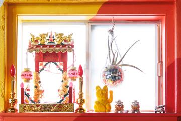 Fun decorations in the window of Café Cà Phê including a disco ball plant holder, lucky cat and dragons