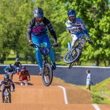 BMX riders going through the air off a hill